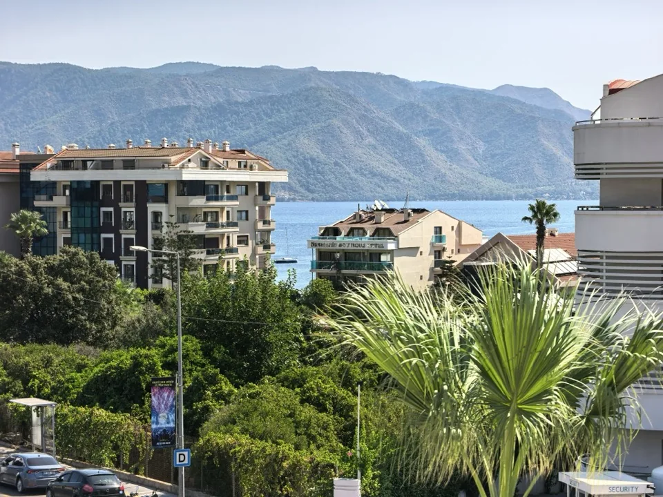 Balkondan Marmaris körfezi — deniz ve karşı yamaçlar