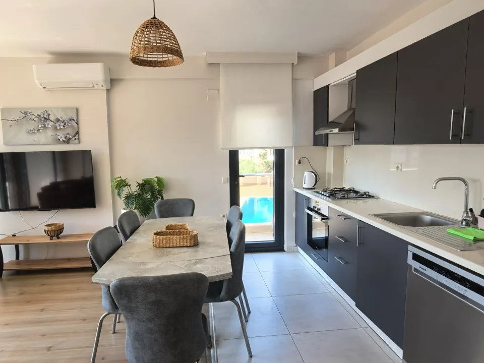 Mutfak ve yemek masası, balkona açılan cam kapı