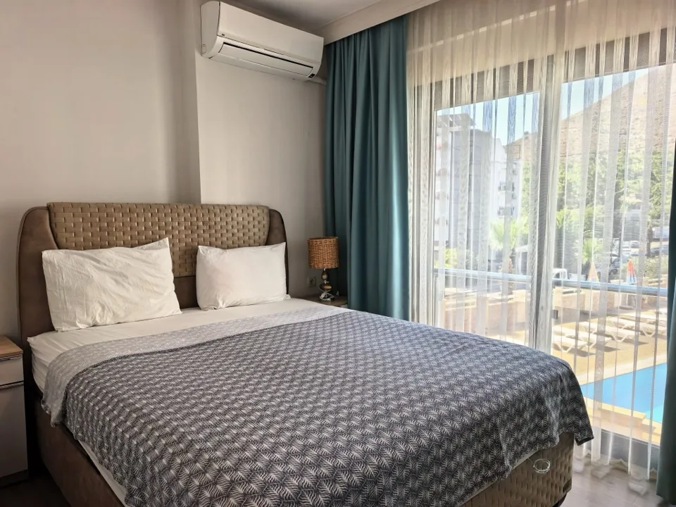 Ebeveyn yatak odası — yataktan balkon ve pencere görünümü