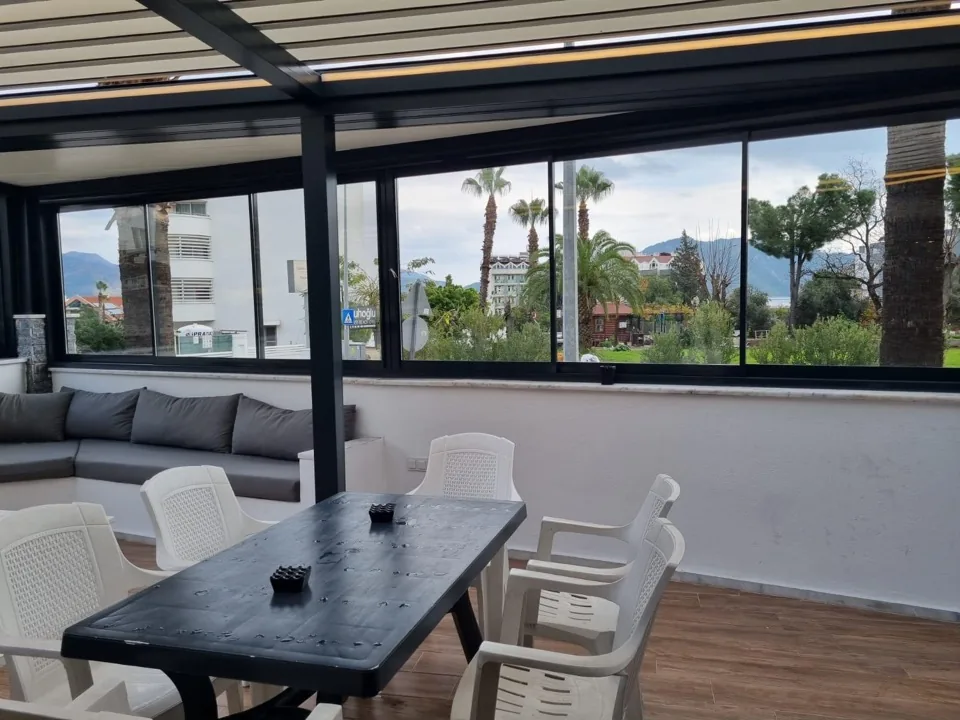 Teras yemek masası, dışarıya bakan cam cephe