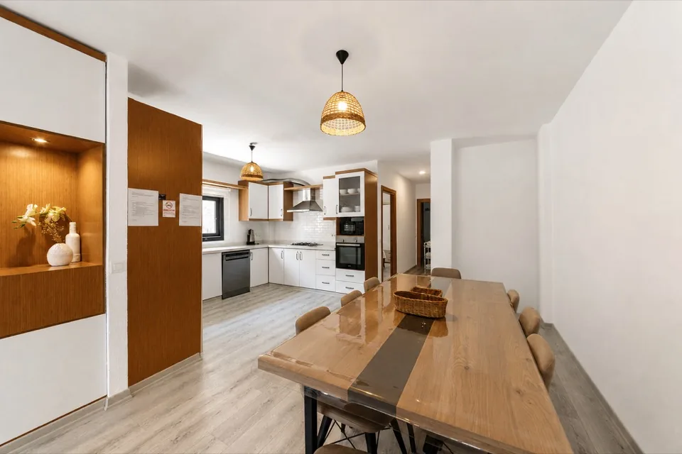 Girişten salona bakış — ahşap bölme ve uzun ahşap yemek masası
